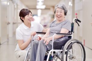 介護職員が車椅子の入居者と笑顔で交流している様子